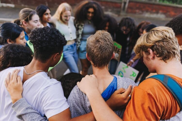 Diverse young people huddled in a circle uniting against climate change