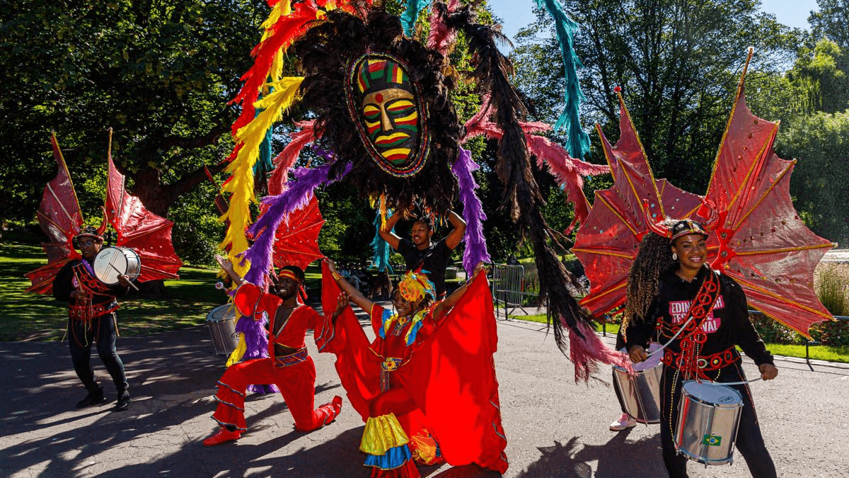 A brightly coloured float with Caribbean-style dancers takes part in the Edinburgh Jazz Festival parade