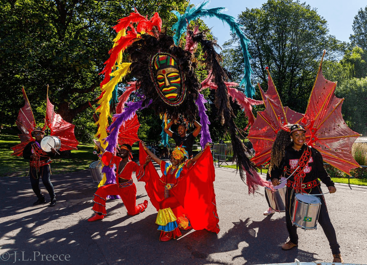 A brightly coloured float with Caribbean-style dancers takes part in the Edinburgh Jazz Festival parade