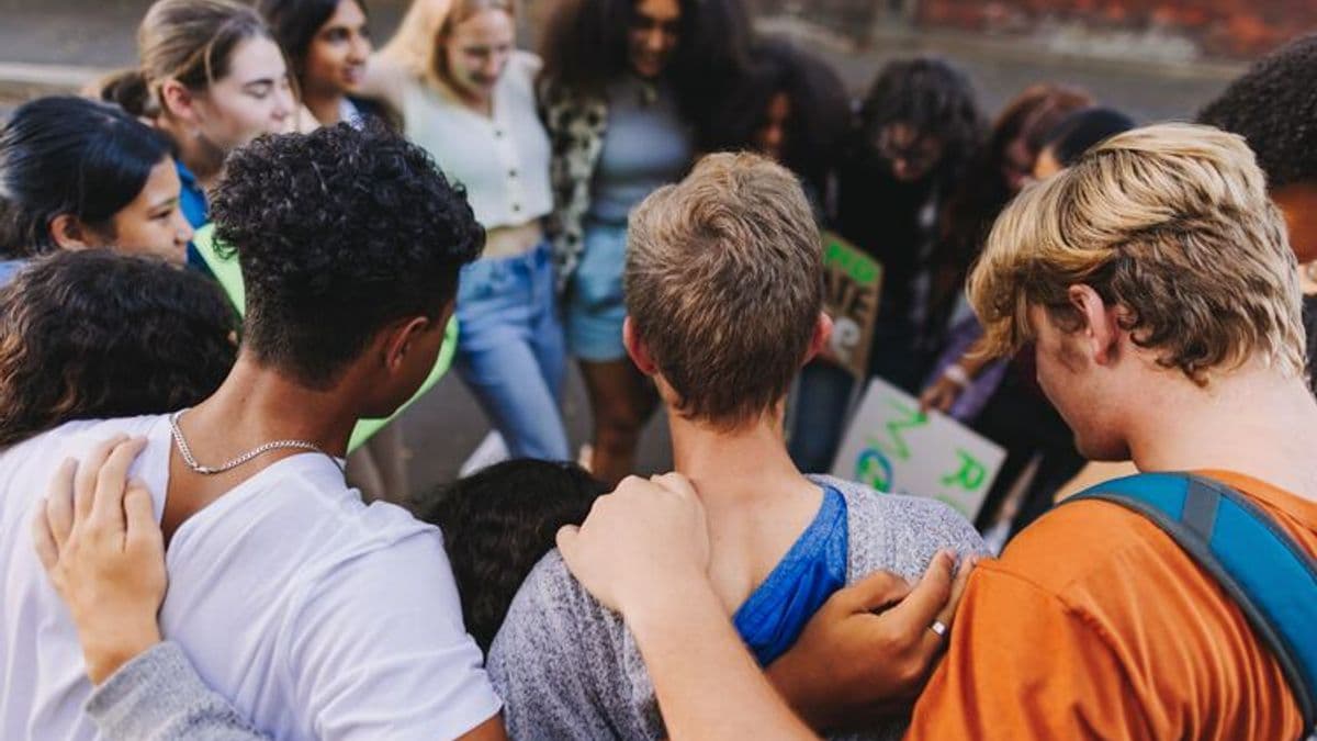 Diverse young people huddled in a circle uniting against climate change