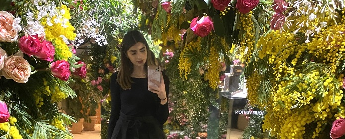 Erasmus+ participant taking selfie and surrounded by flowers