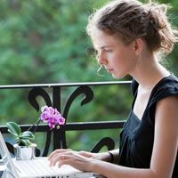 Woman typing on balcony